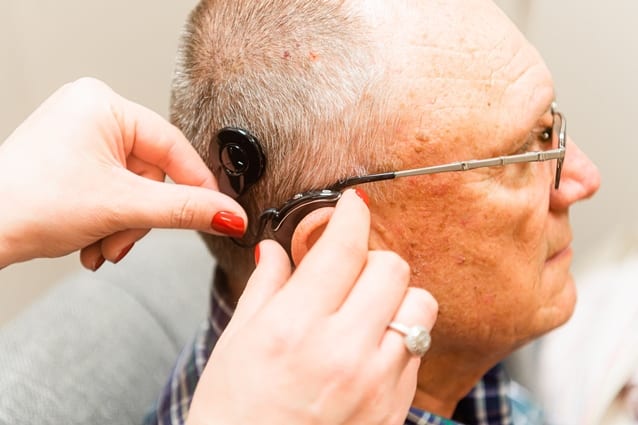 Cochlear implant doctor placing hearing implant device